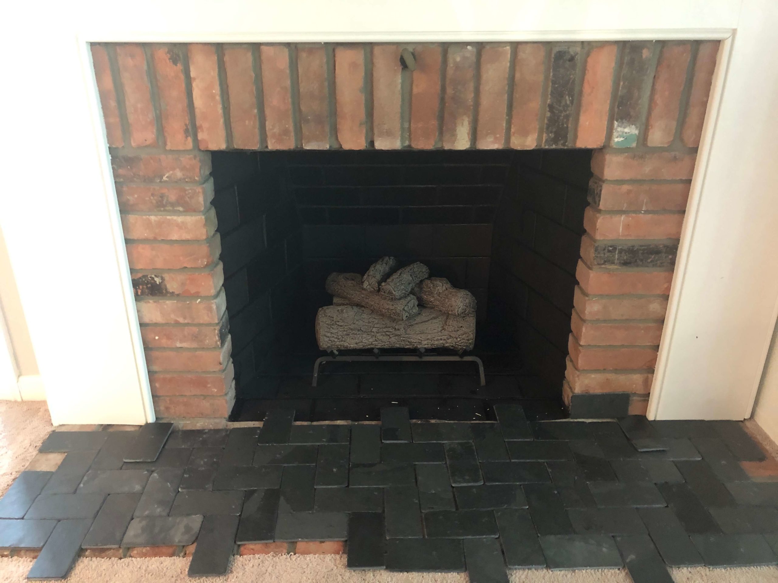 Testing 90-degree slate herringbone on pink bricked fireplace