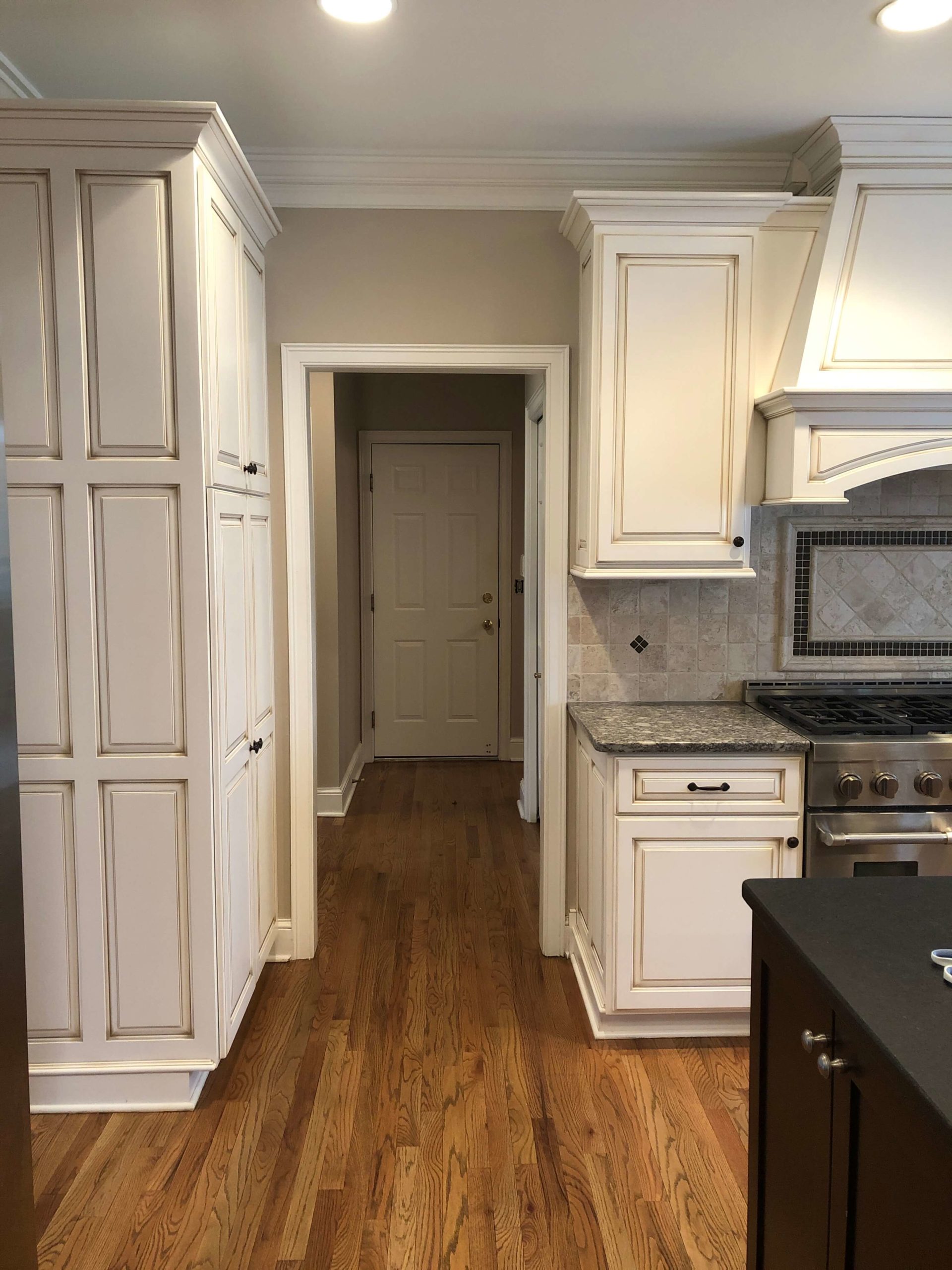 Progress photo of taupe cabinetry in kitchen space with yellow beige floors, cherry cabinetry, and a pink beige backsplash