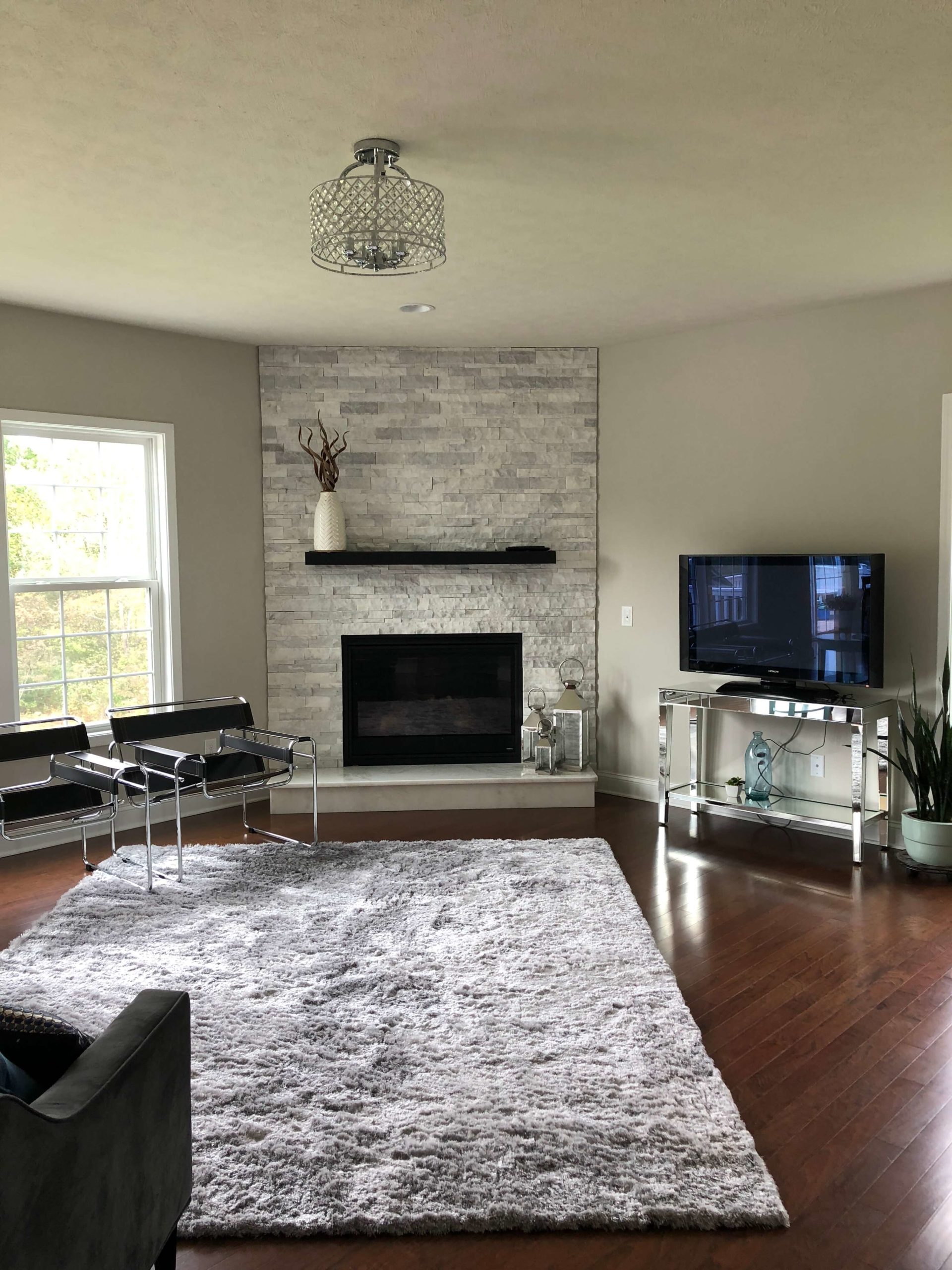 walls are green gray, the fireplace is blue gray, and the rug is purple gray. It’s not the best color for this room. Lindsey Putzier Design Studio 