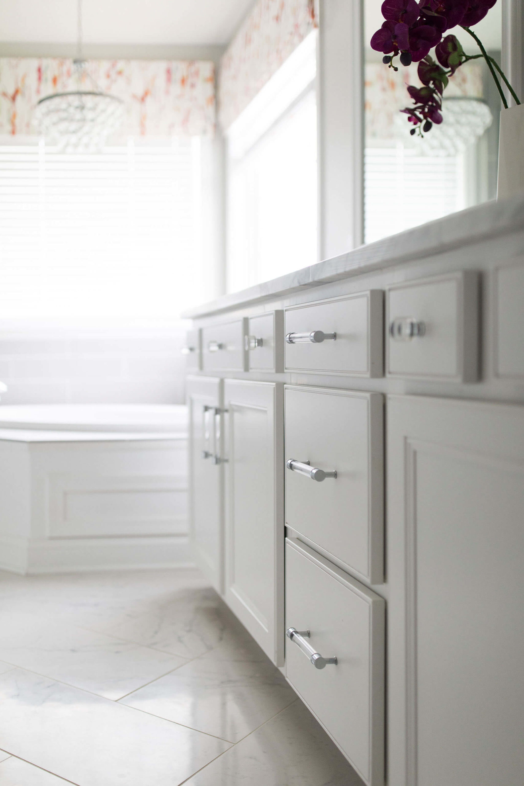 Master Bathroom Space after adding colorful custom valences, a beautiful chandelier, and acrylic hardware Lindsey Putzier Design Studio