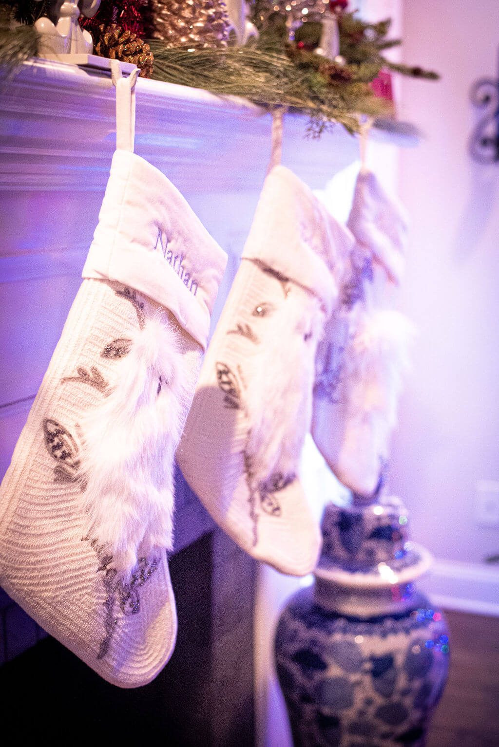 Family stockings hung upon the fireplace mantel for Christmas holiday season Lindsey Putzier Design Studio