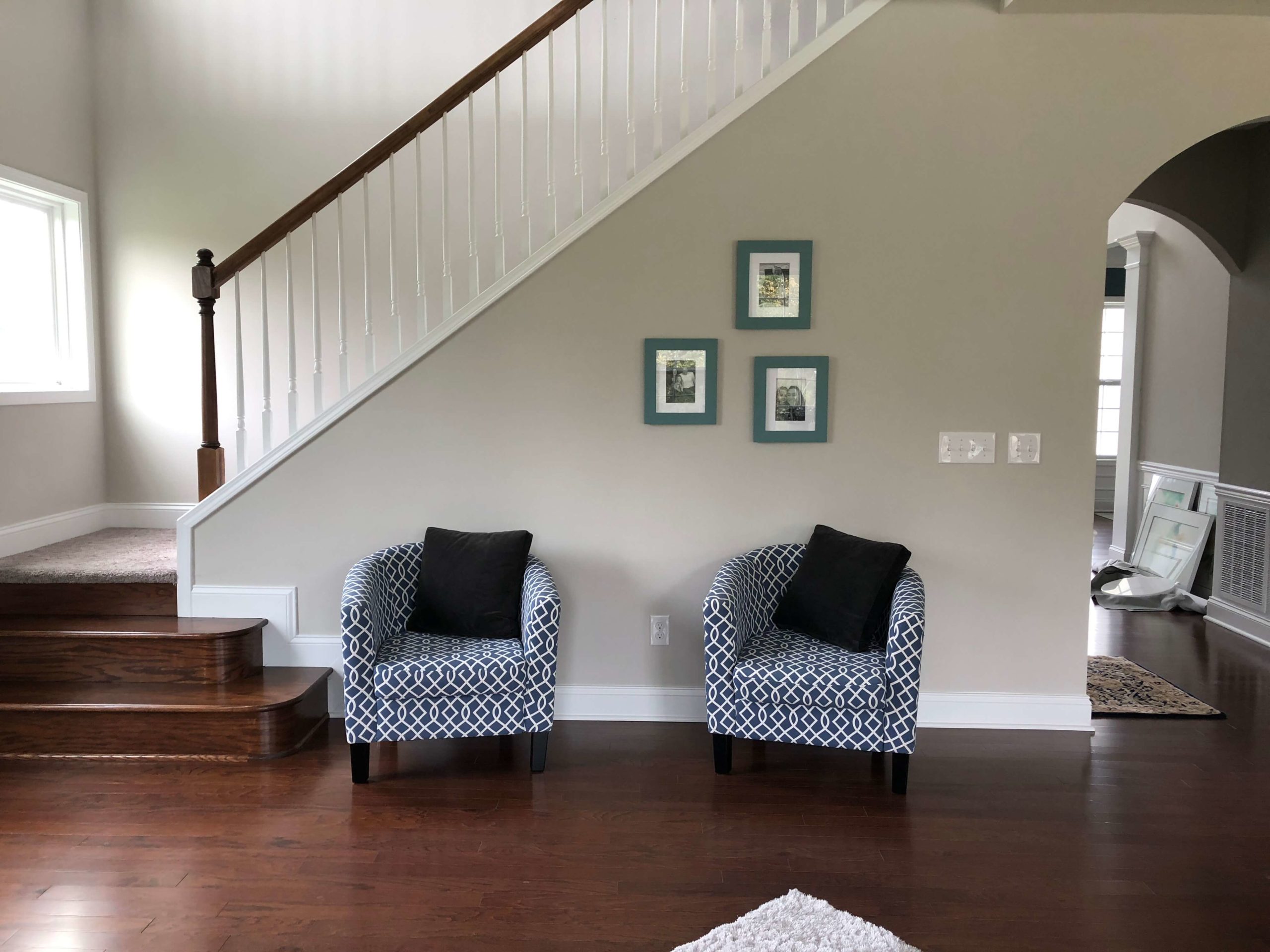 Before photo of Family Room chairs pushed against stairway wall Lindsey Putzier Design Studio