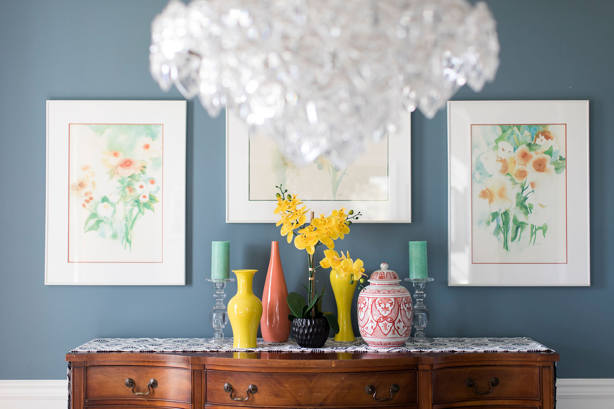 Dining Room Buffet with punchy yellow and coral vases, sea foam green candlesticks, and watercolor florals Lindsey Putzier Design Studio