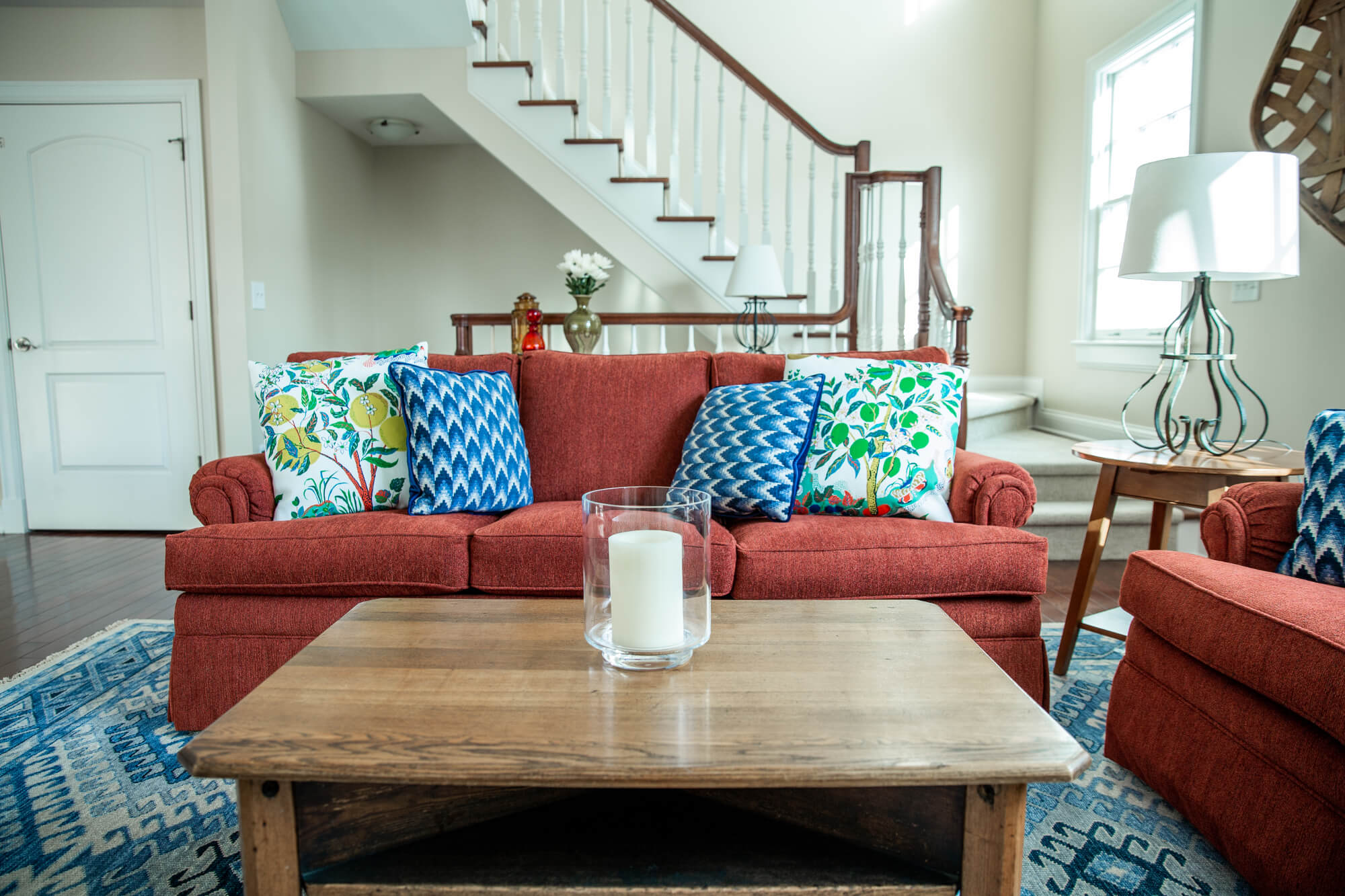 Buffet behind Burnt orange sofa with custom pillows Living Room Lindsey Putzier Design Studio