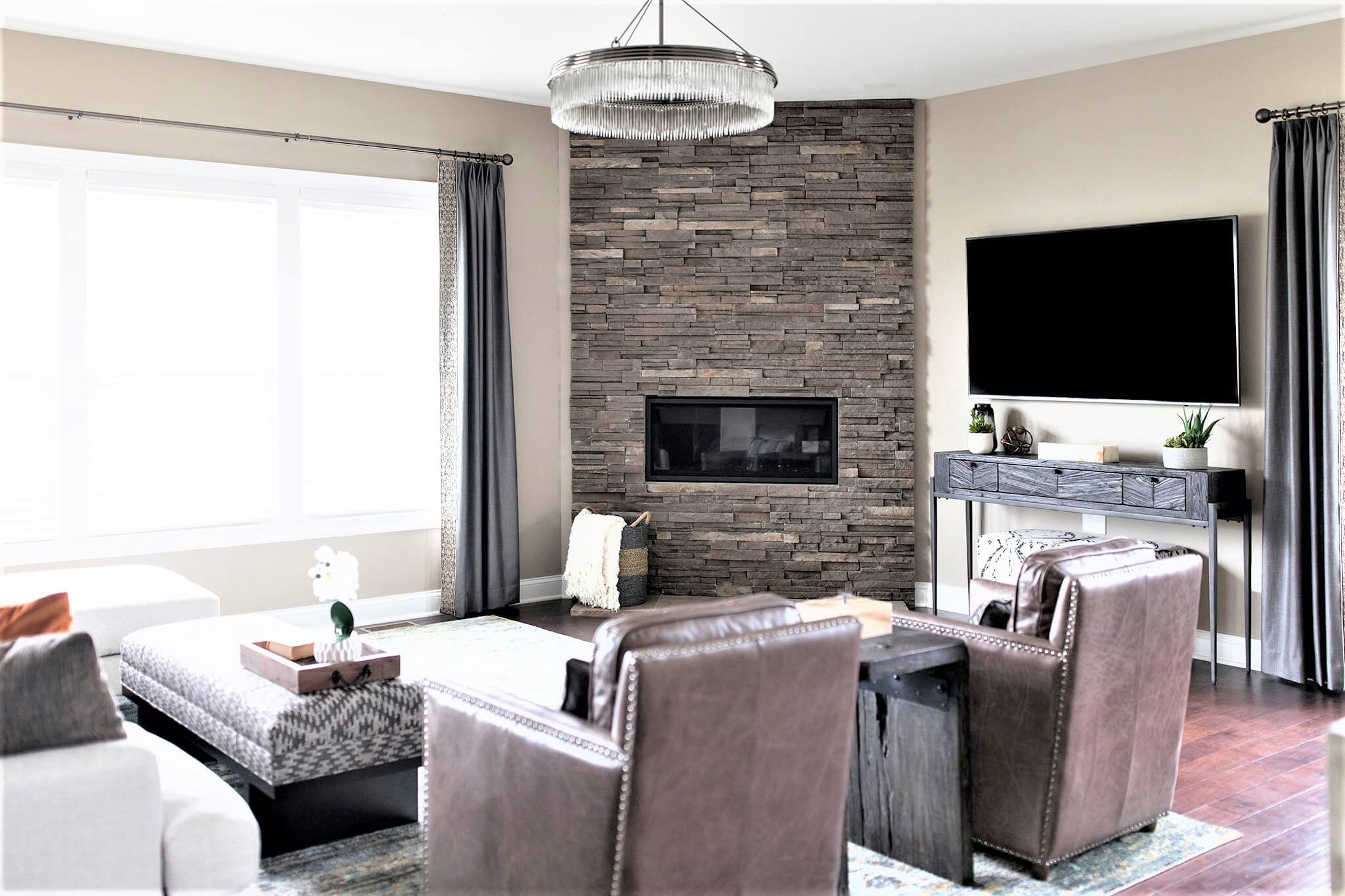 Client's floor-to-ceiling stacked stone Fireplace After in Family Room Space Lindsey Putzier Design Studio