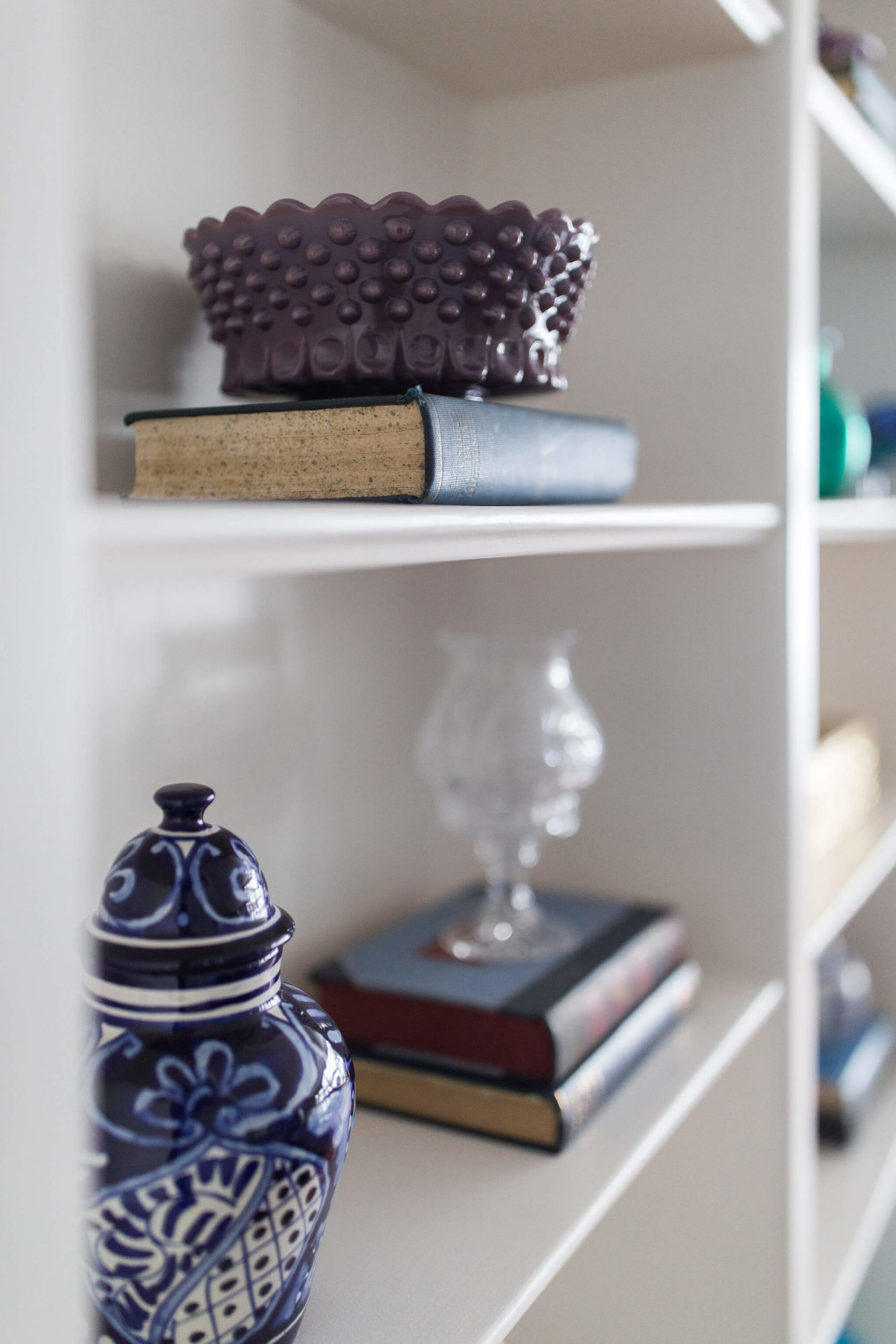 Family Room Built-in Shelves After Lindsey Putzier Design Studio with accessories like purple hobnail glassware