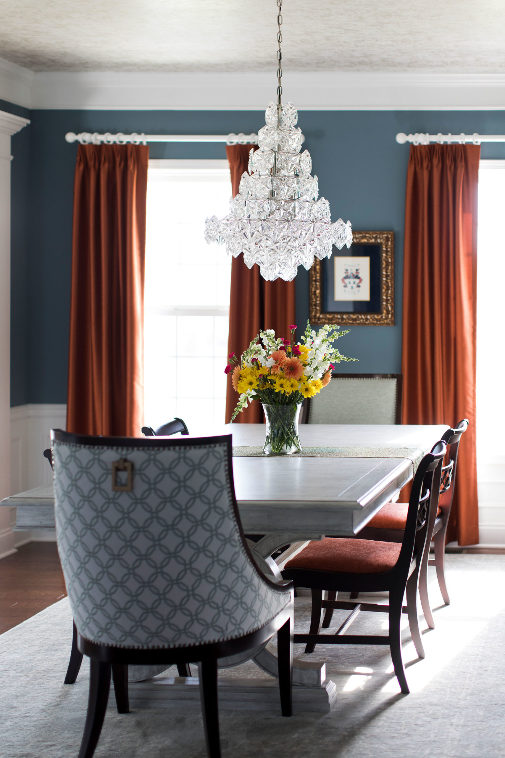 Orange Drapery panels contrasting blue walls in Dining Room Space Lindsey Putzier Design Studio