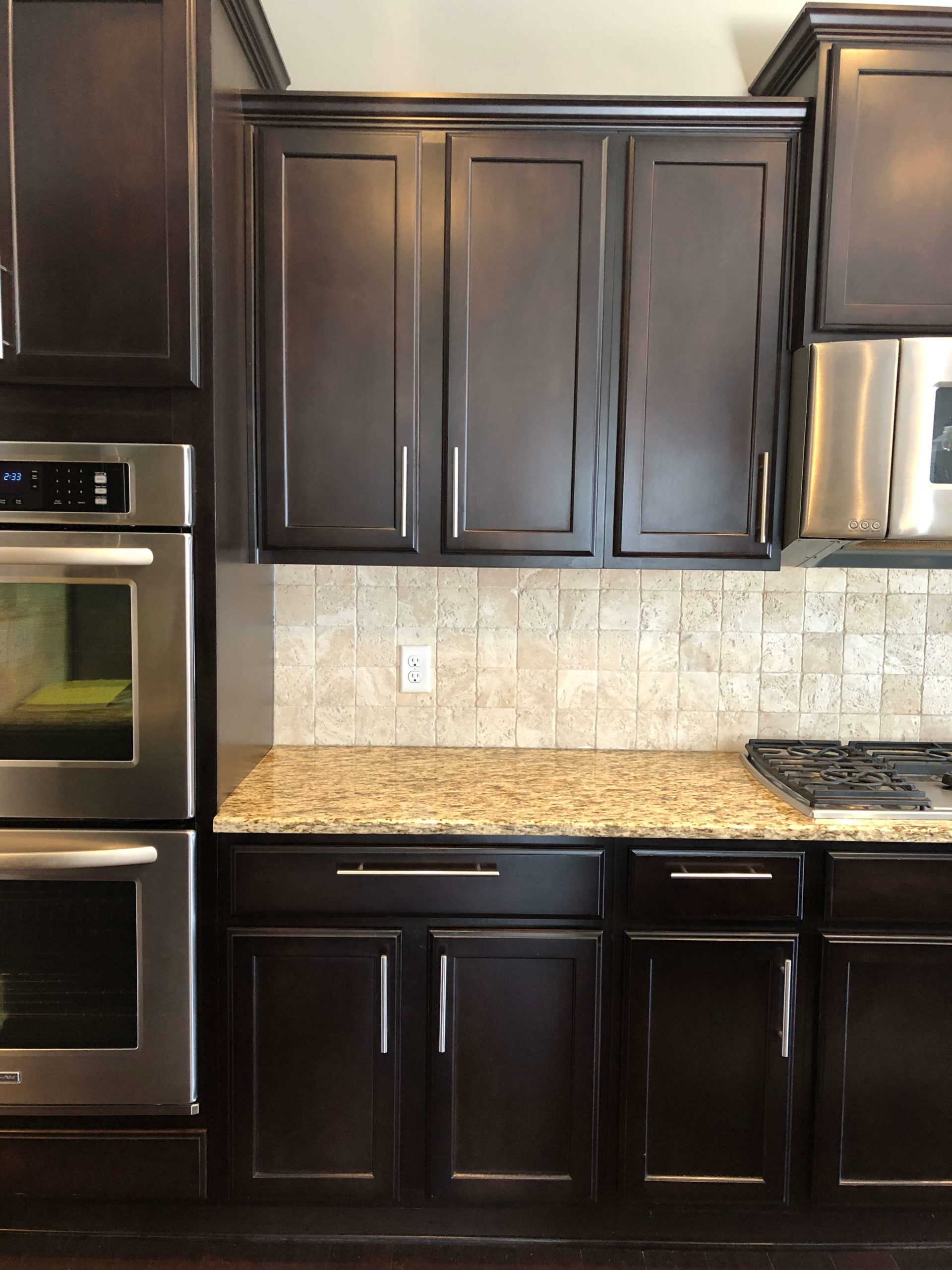 tan and brown granite with espresso cabinets in Kitchen Space Lindsey Putzier Design Studio