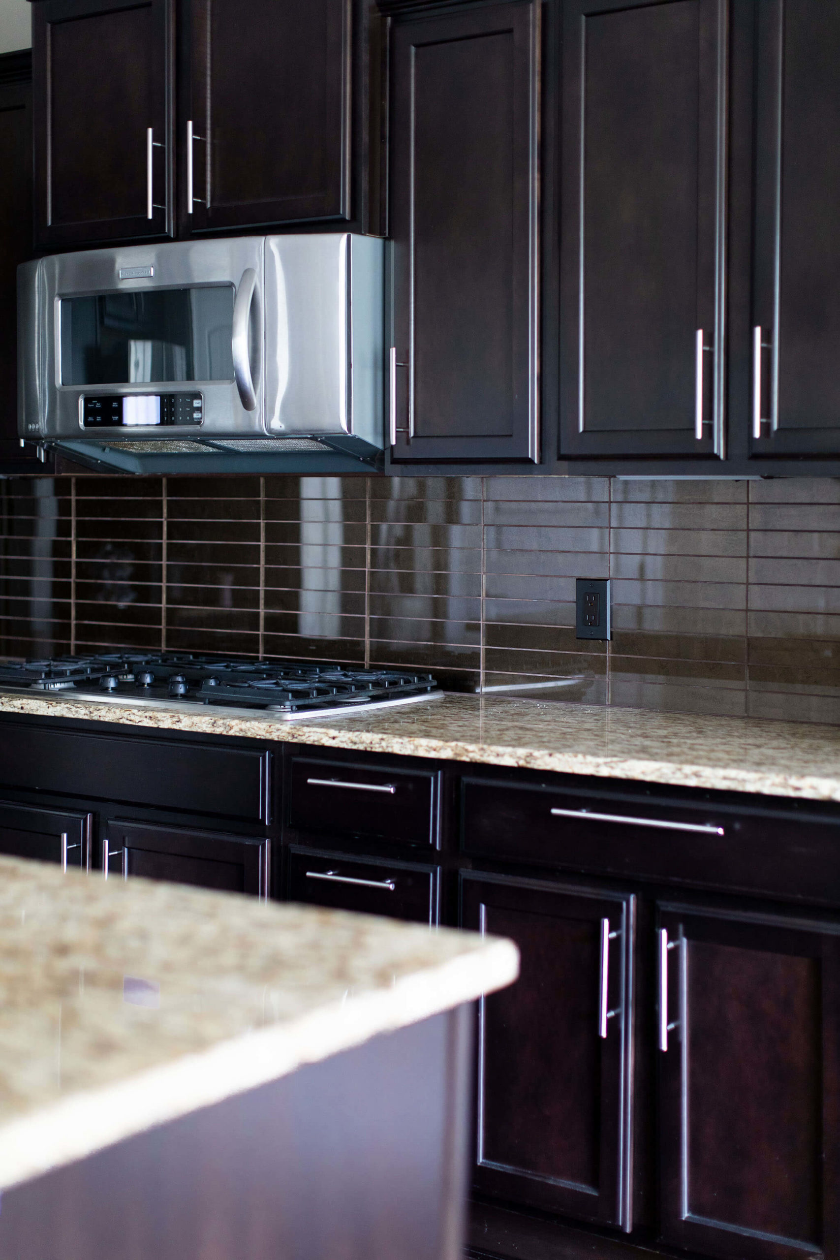 Kitchen After Photo Ann Sacks modern glass backsplash tile, dark grout color and oil-rubbed bronze outlets.