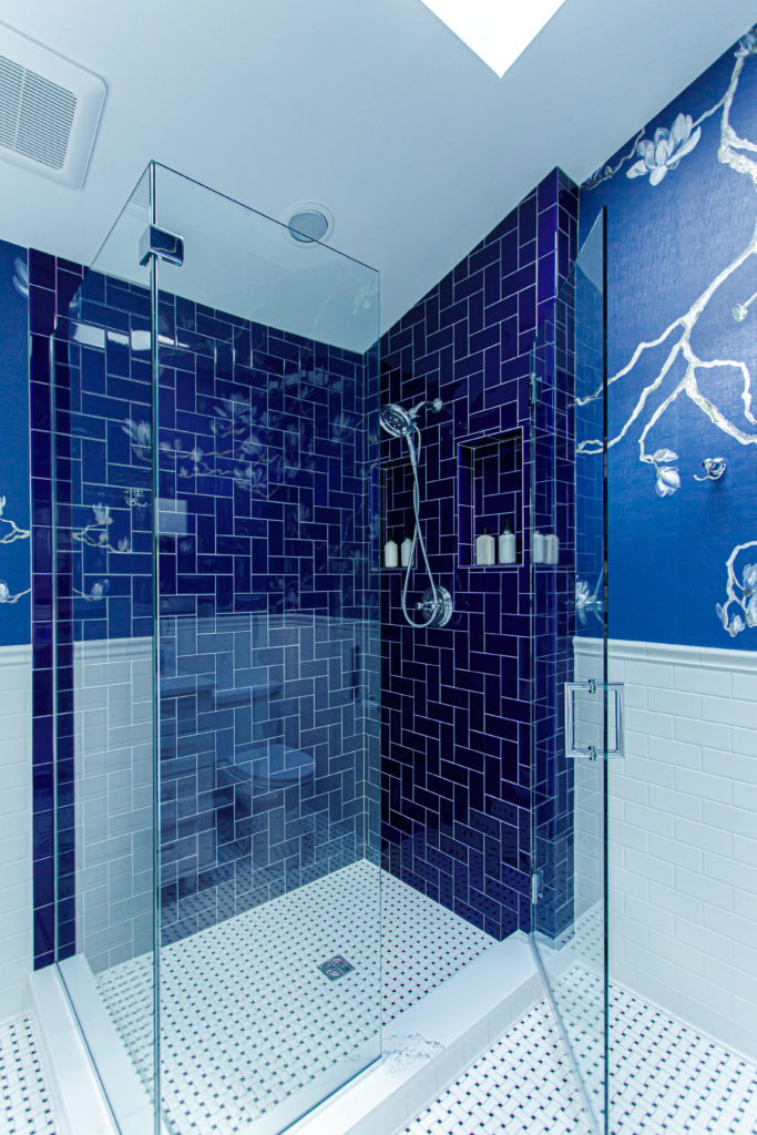 blue herringbone shower with seamless glass shower doors  Lindsey Putzier Design Studio