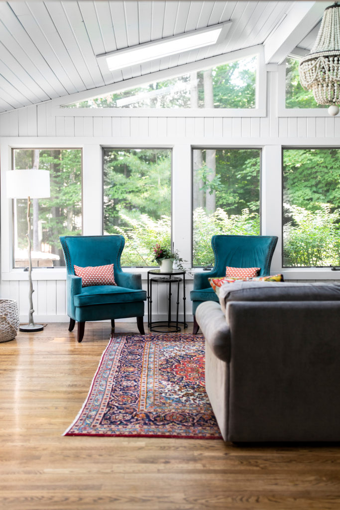 Teal lounge chairs with nesting side table, wooden base floor lamp, wooden floors, and gray sectional Lindsey Putzier Design Studio