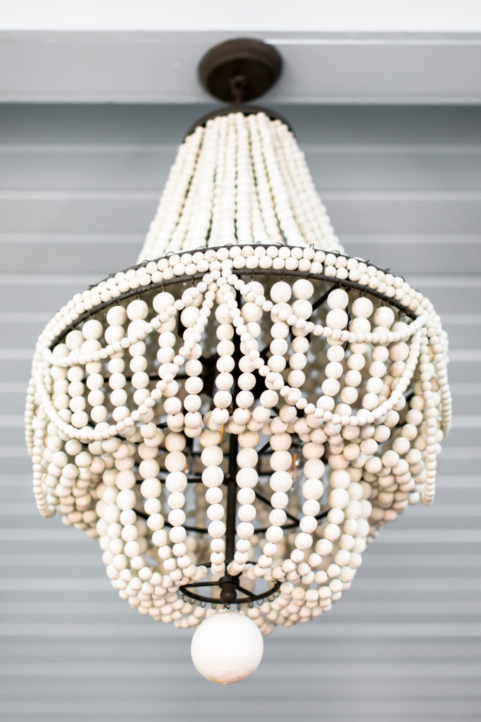 New Chandelier in Sunroom A bevy of draped wooden beads in weathered white, dresses up the steel structure Lindsey Putzier Design Studio