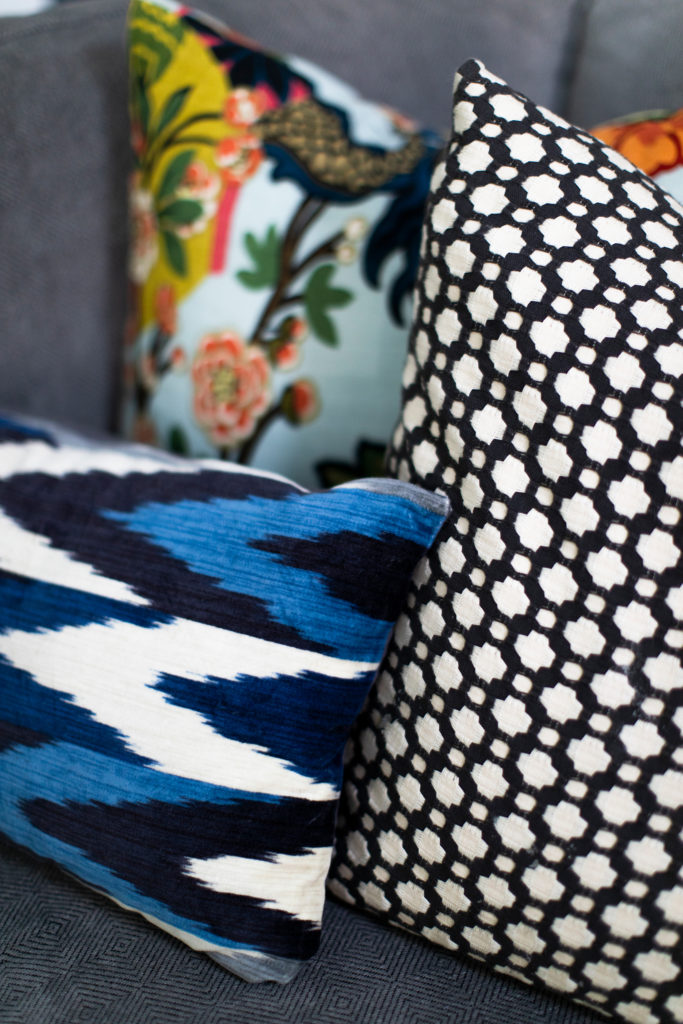 Patterned, multi colored accent pillows for grey sectional in Sunroom Lindsey Putzier Design Studio