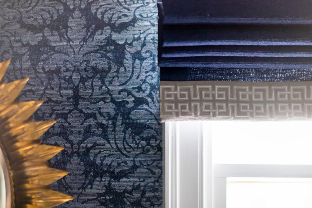 Custom dark blue Roman shade with Greek key trim. Lined in white. Cordless draw. Lindsey Putzier Design Studio
