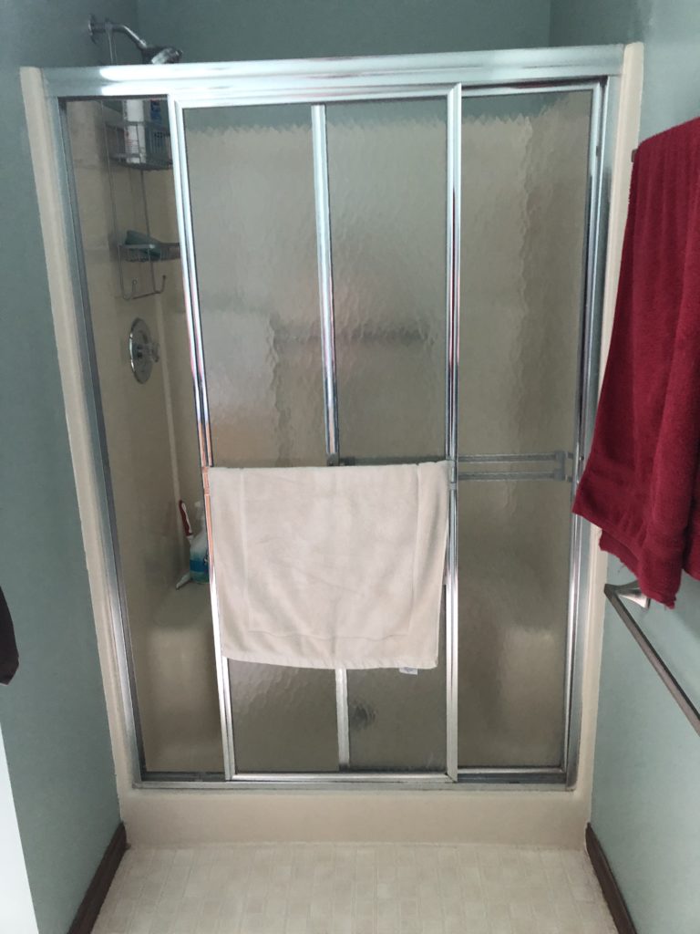 Shower with metal rack hanging on the head for washing supplies Lindsey Putzier Design Studio