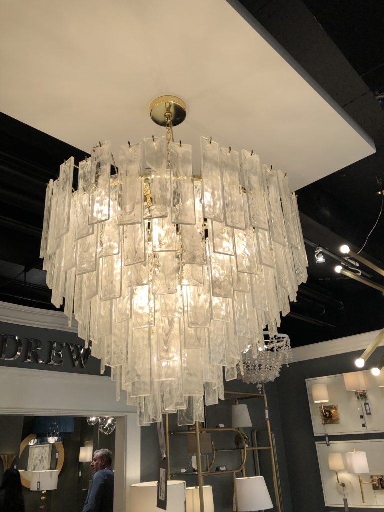 Tiered opaque white tiles surround chandelier Lindsey Putzier Design Studio