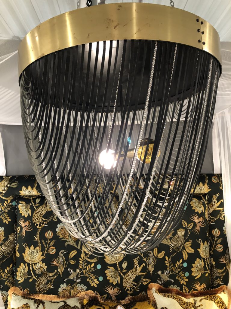 Black fabric and clear beaded strands draped across the bottom of a golden chandelier base Lindsey Putzier Design Studio