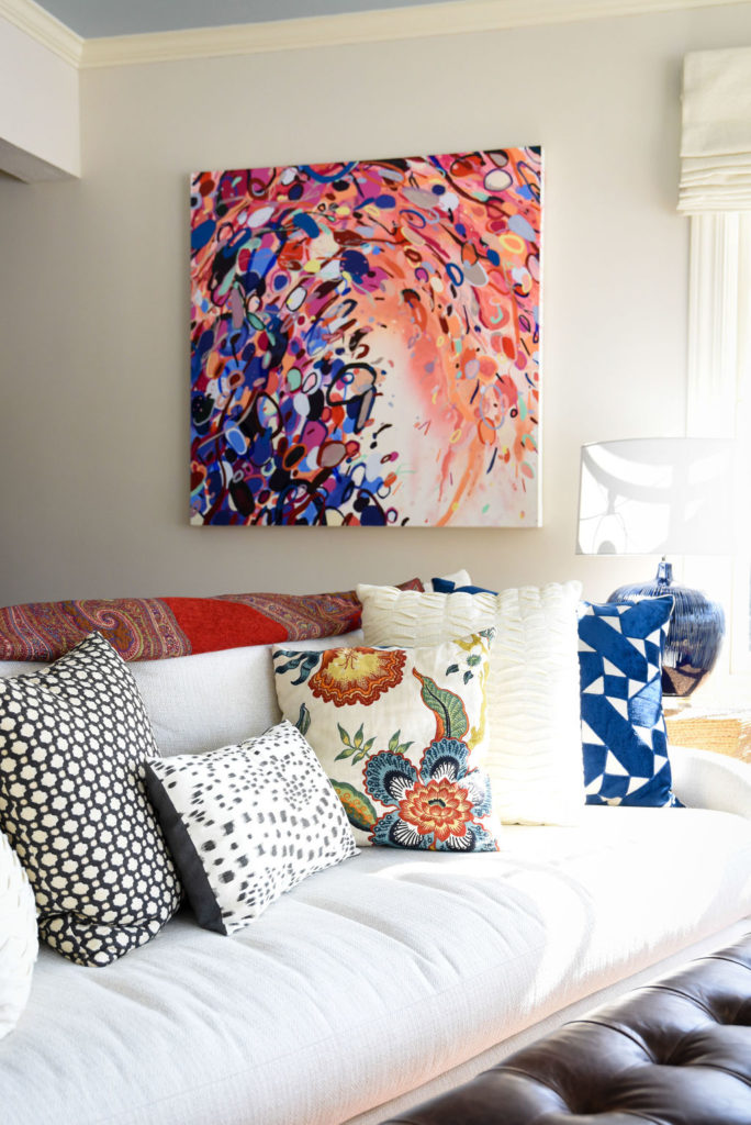 White sofa with custom colorful accent pillows and colorful painting Lindsey Putzier Design Studio