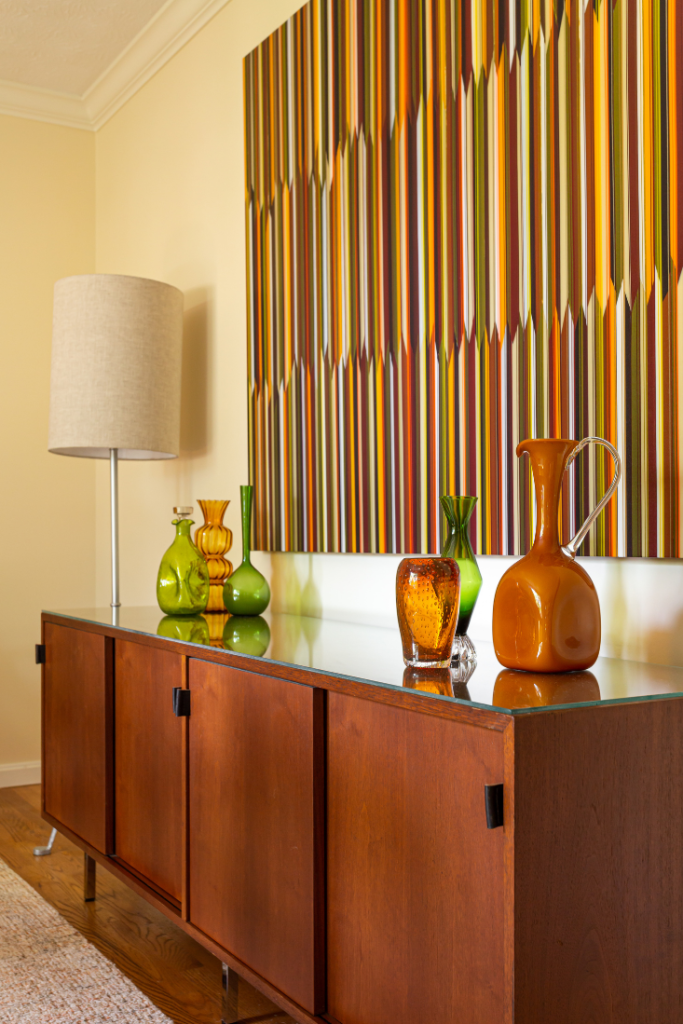 Low-profile cabinet with leather handles and abstract art piece Lindsey Putzier Design Studio