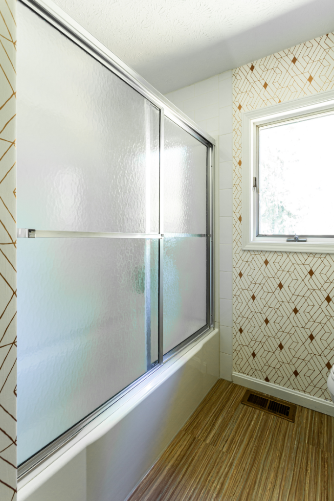 After image of Mid-Century Upstairs guest bathroom with metallic abstract wallpaper Lindsey Putzier Design Studio