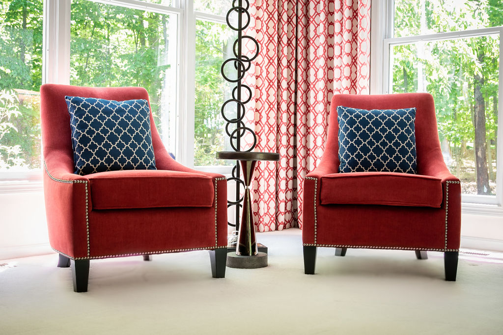 Round drink table between two red chairs Lindsey Putzier Design Studio