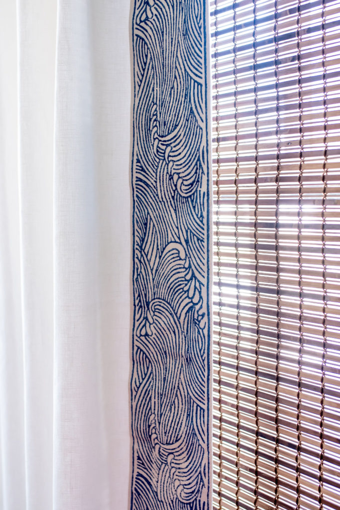 Closeup of shutters and custom window treatment in Living Room White fabric with swirly wave/cloud pattern on the trim Lindsey Putzier Design Studio